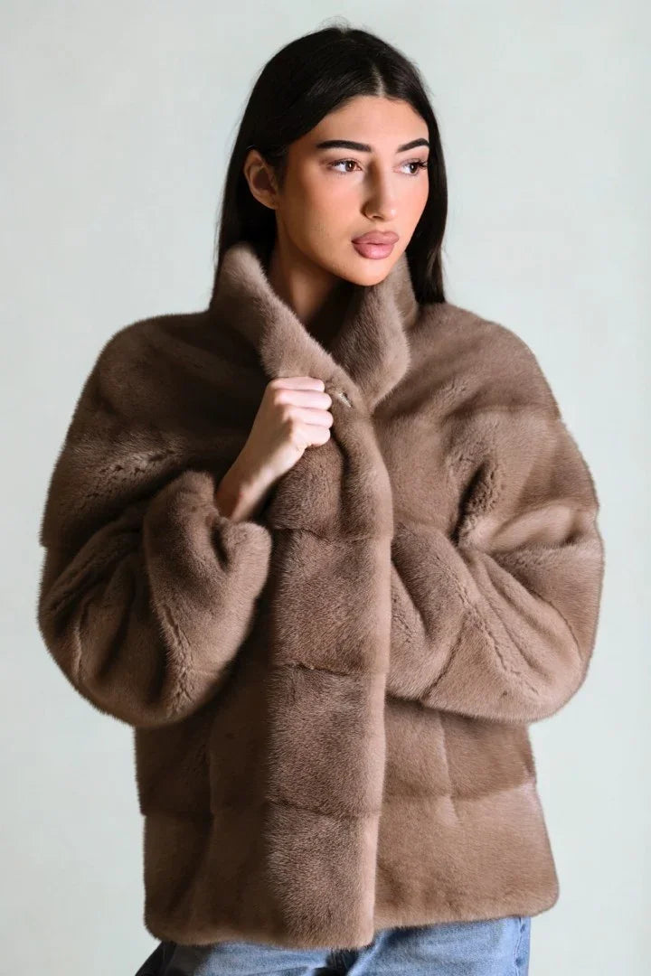 Woman wearing a luxurious brown faux fur coat with a high collar