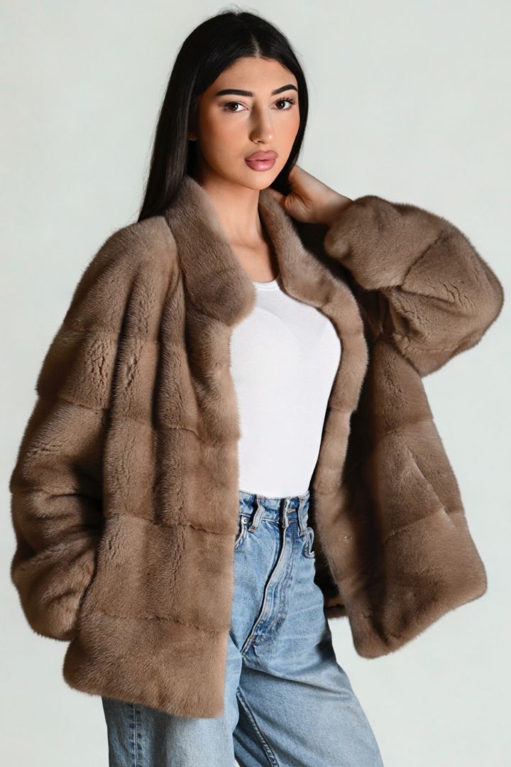 Woman wearing a brown fur coat with a plain background