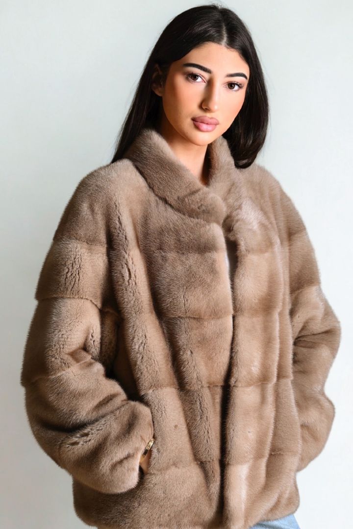 Woman wearing a brown fur coat against a white background