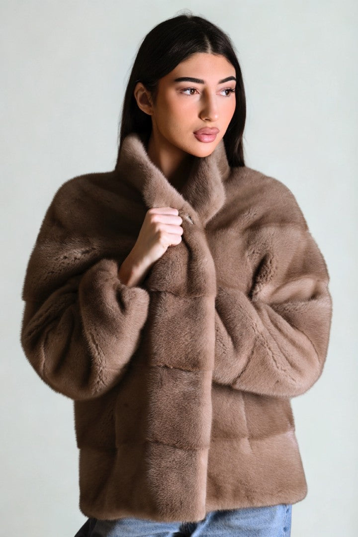 Woman wearing a brown fur coat against a plain background